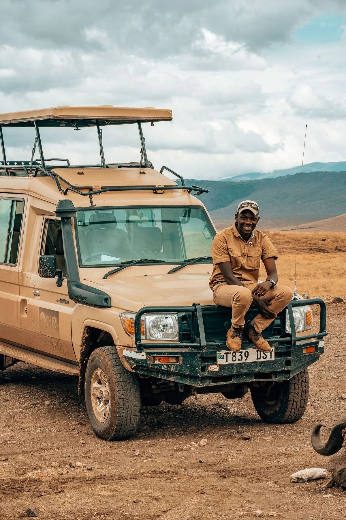 Augustine Nzungu on a Land Cruiser on safari