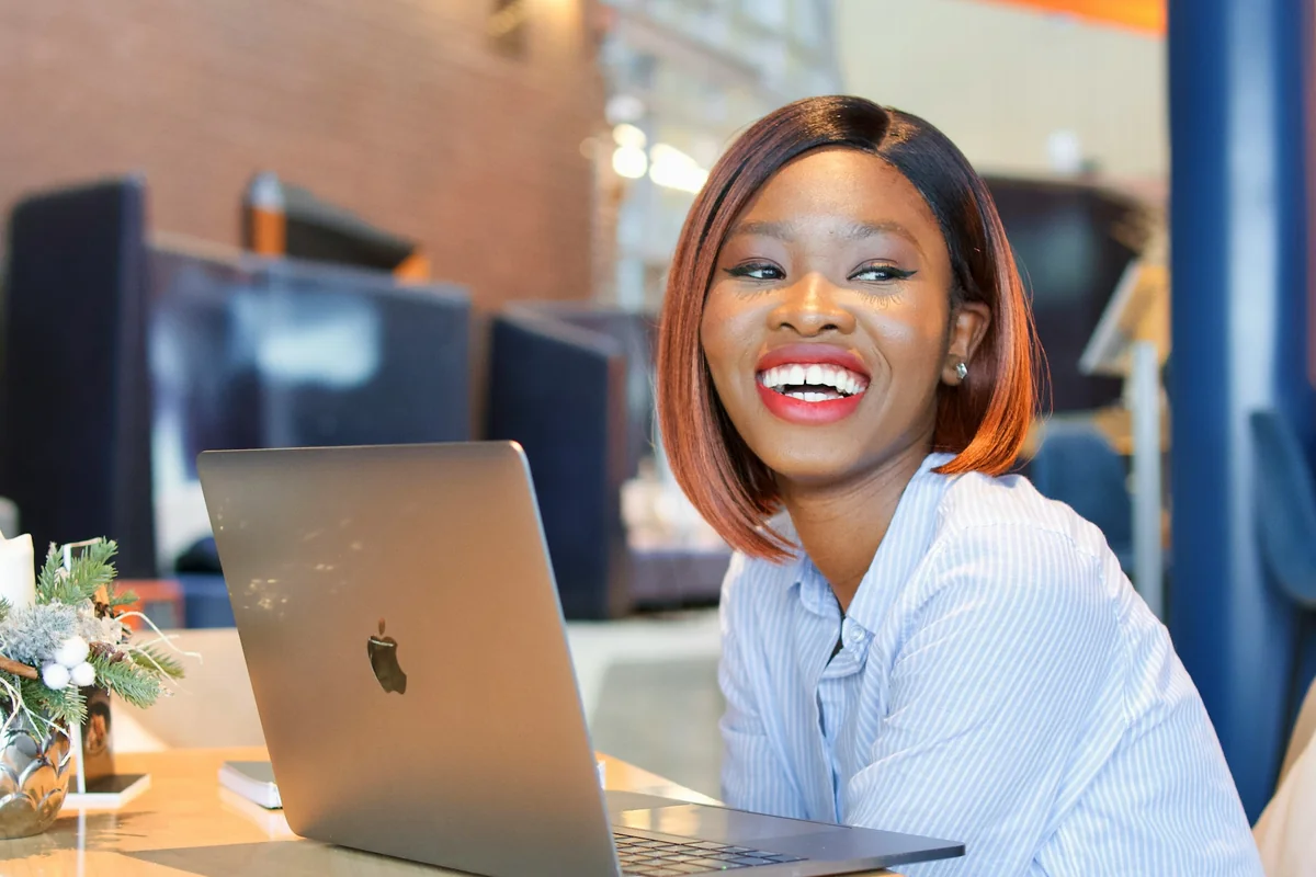 A travel agent smiling at her laptop.