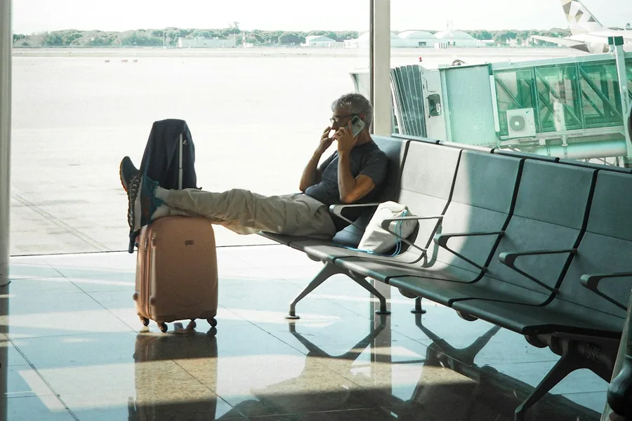 A traveler on a call in an airport lounge.